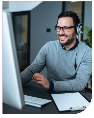 Man with headset smiling at computer