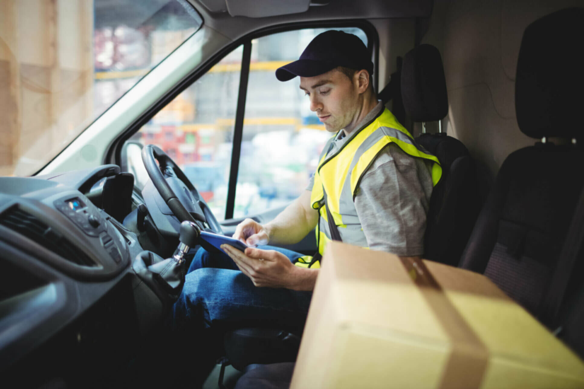 Man in driver's seat of a van in a high-vis vest