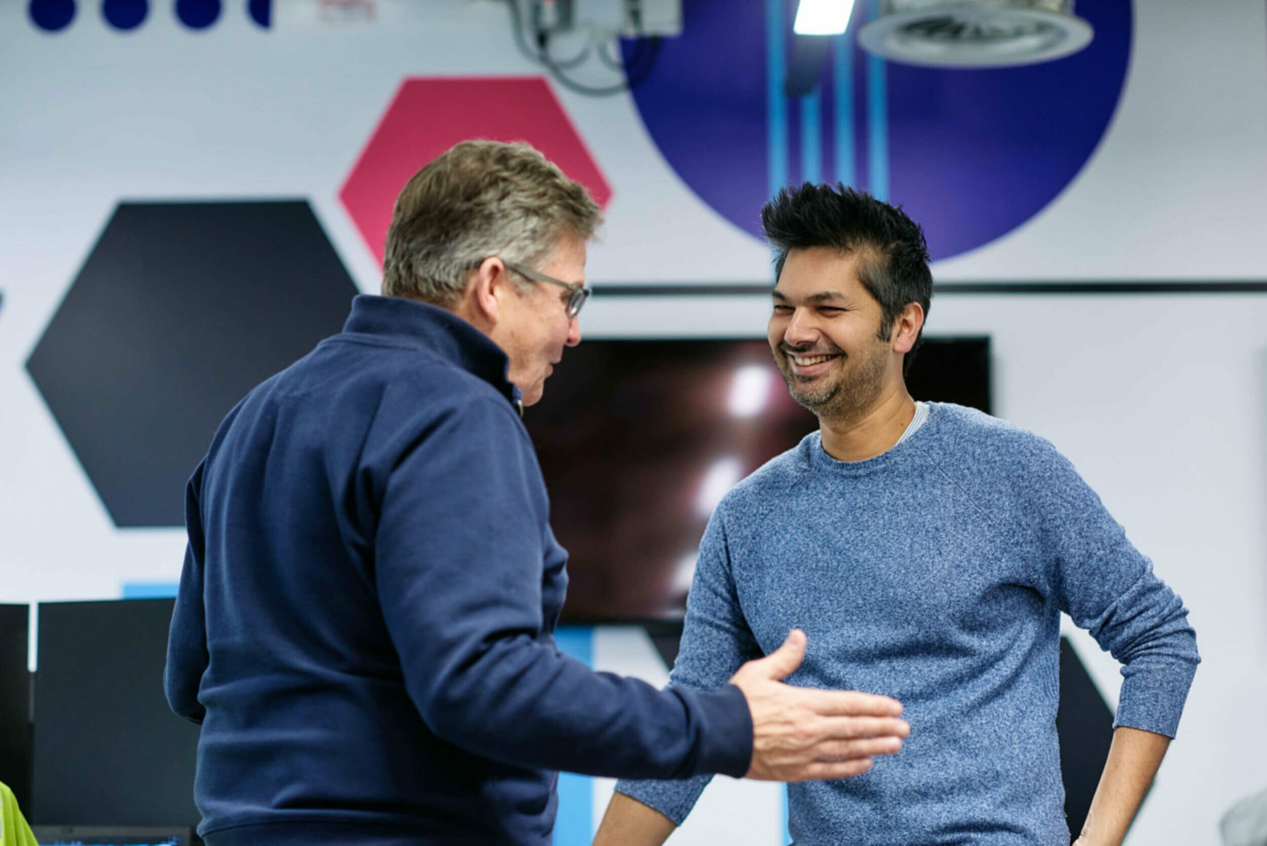 two men talking and smiling