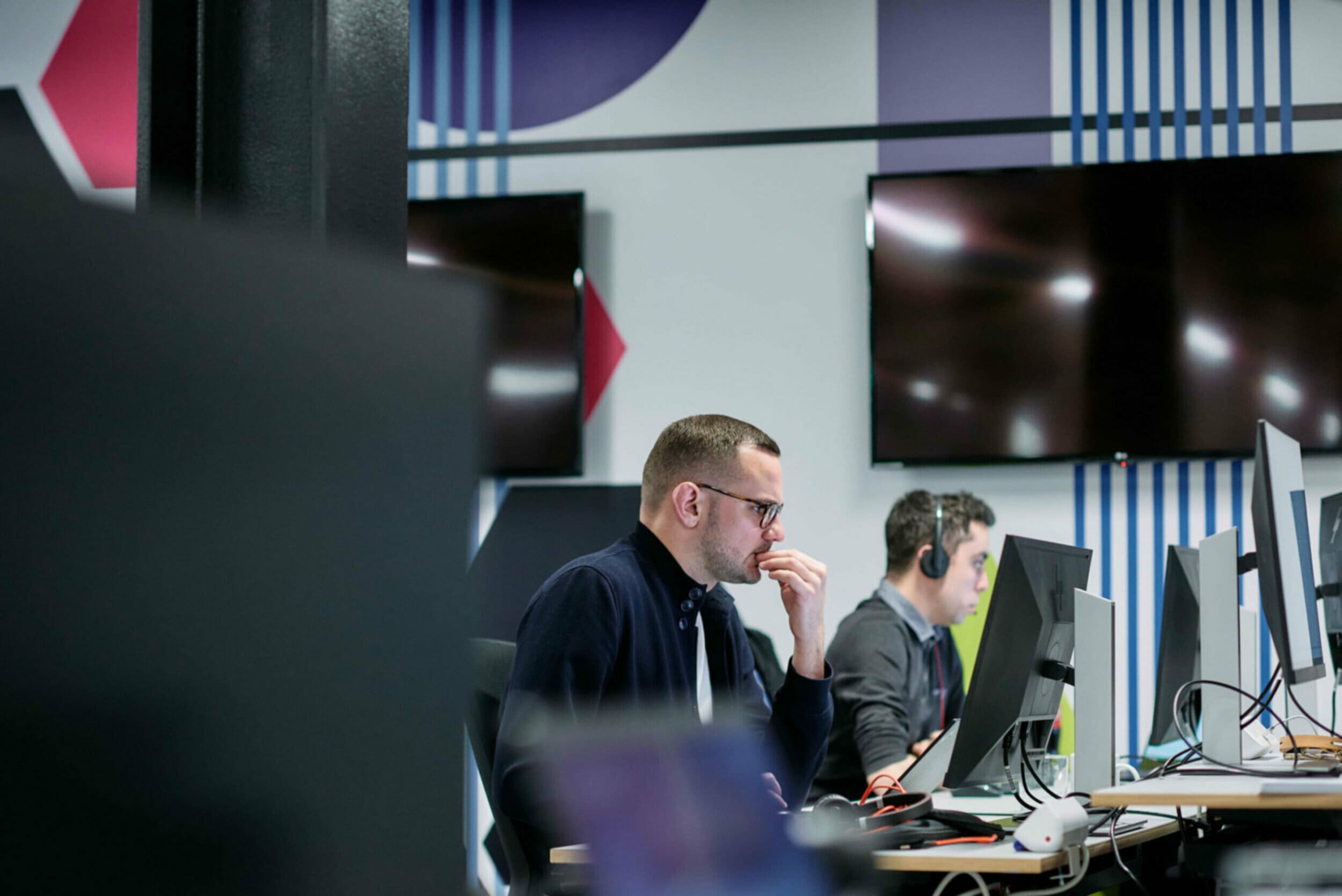 Two men sat at a computer desk in the office