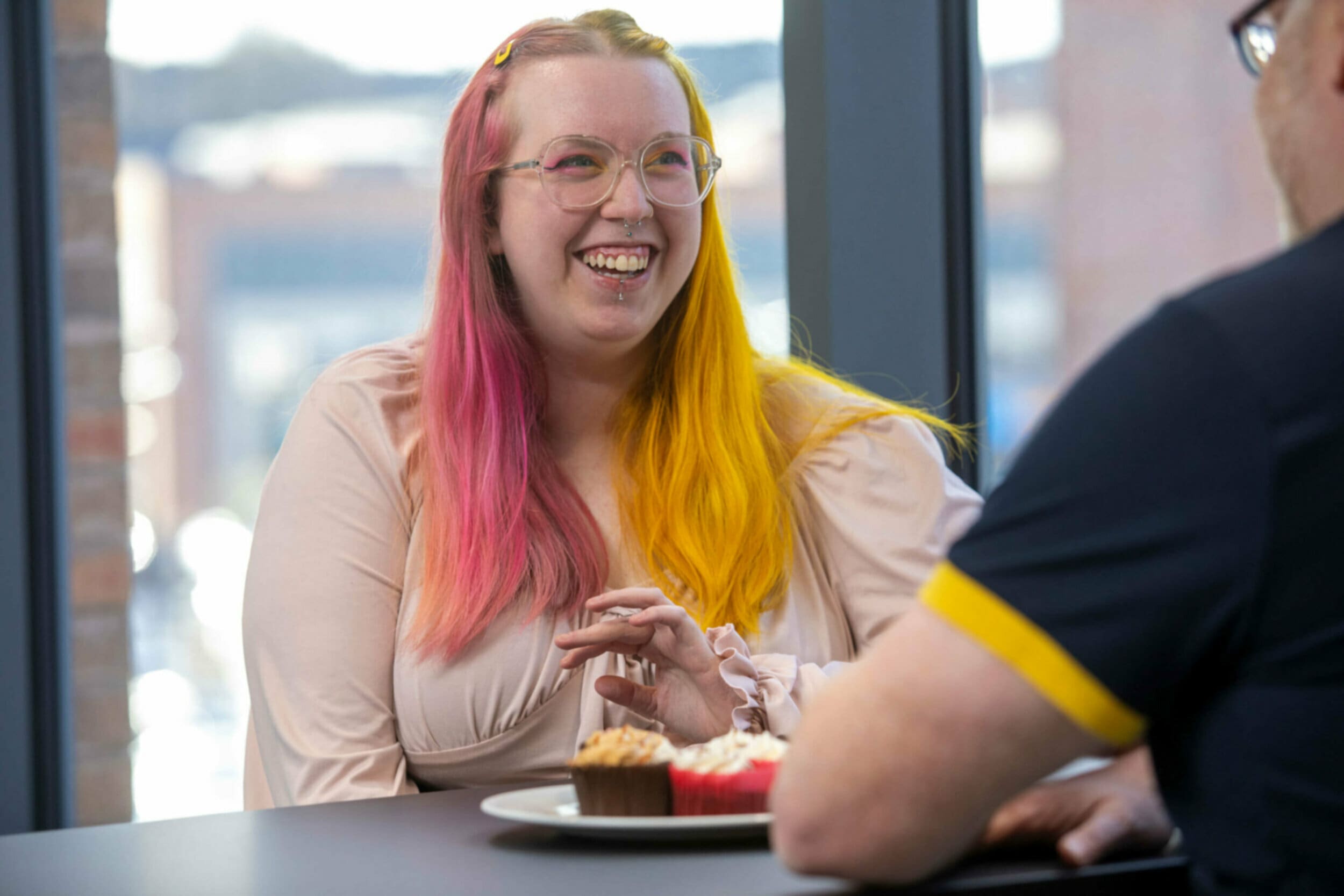 Woman smiling at table with cupcake