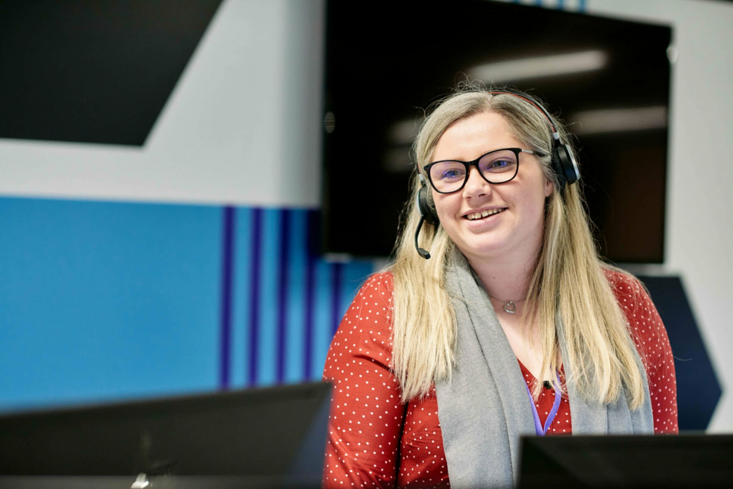 Woman with headset smiling in office