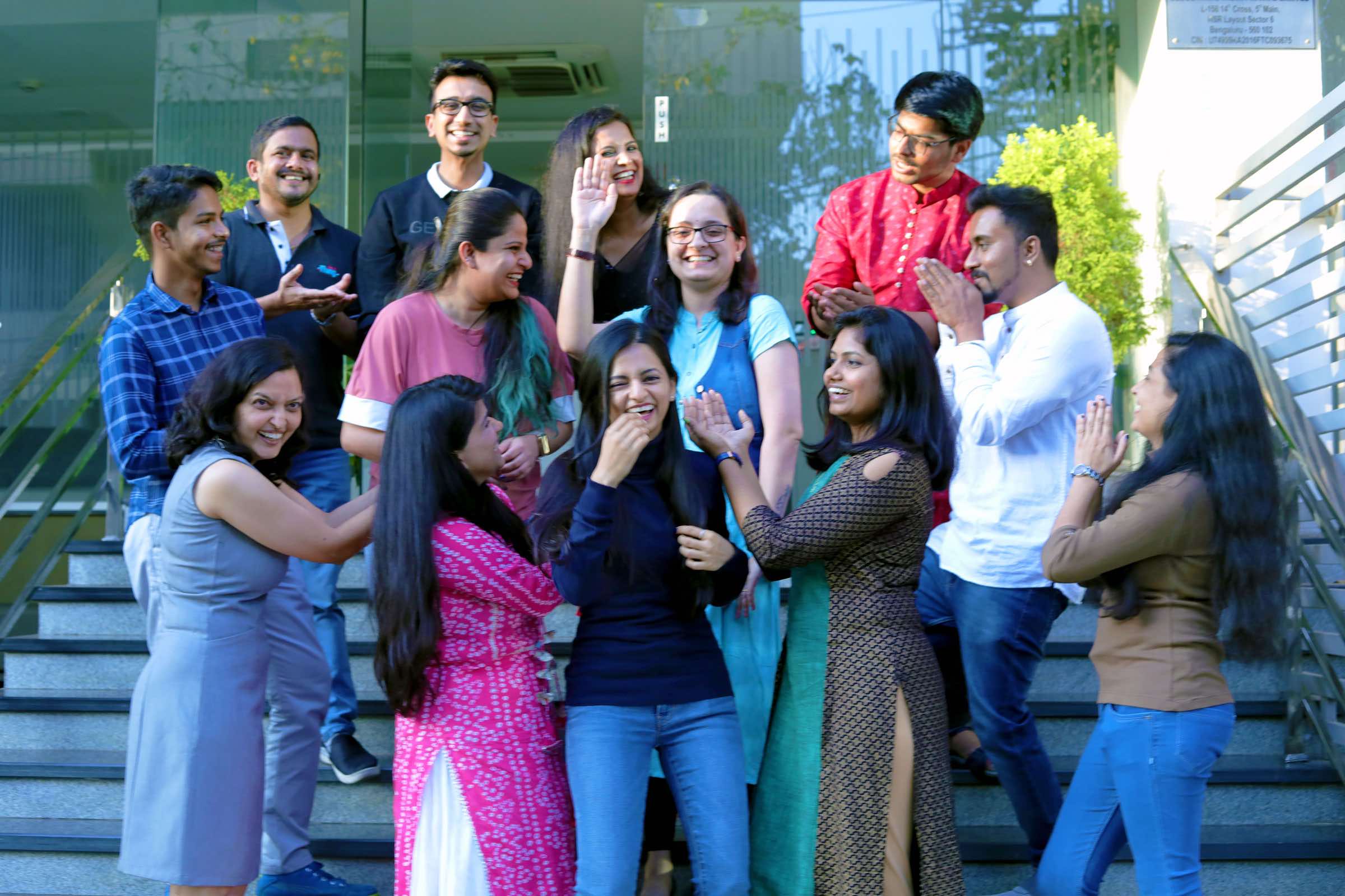 Group of people standing on steps laughing and smiling together