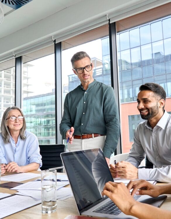 Three people sitting around a desk in an office building