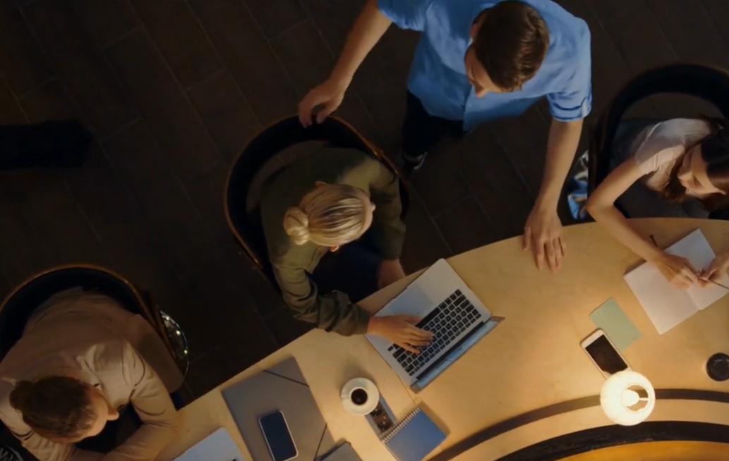 Aerial shot of people at desk with laptops