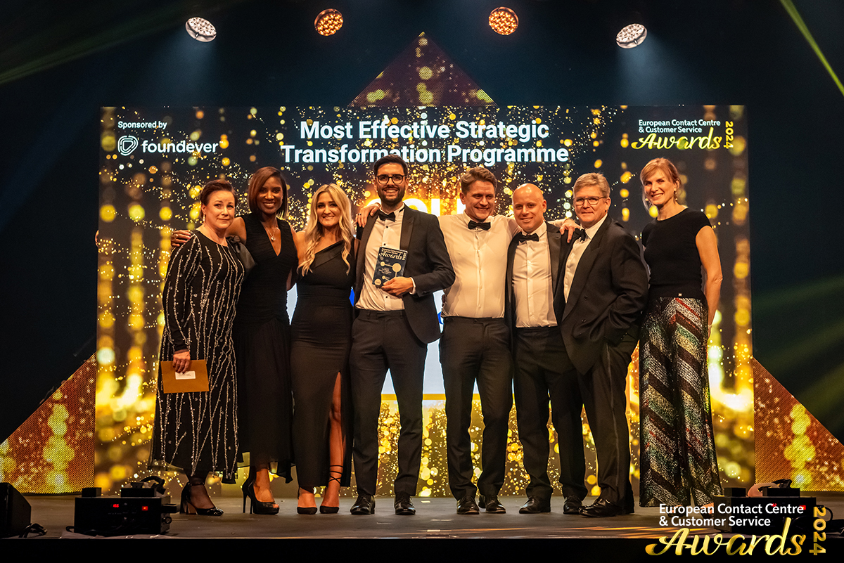 group of people smiling and receiving an award