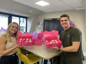 Man and woman posing with boxes of cupcakes