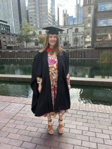 woman posing in graduation cap and gown